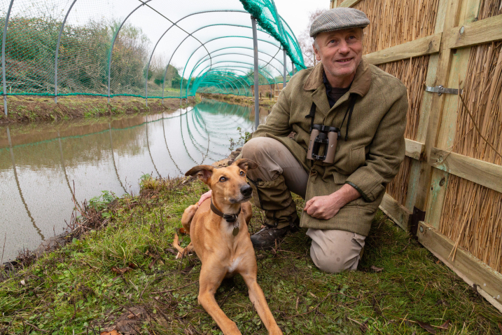 Dave Paynter with dog Piper in the Duck Decoy at Slimbridge Wetland Centre.jpg